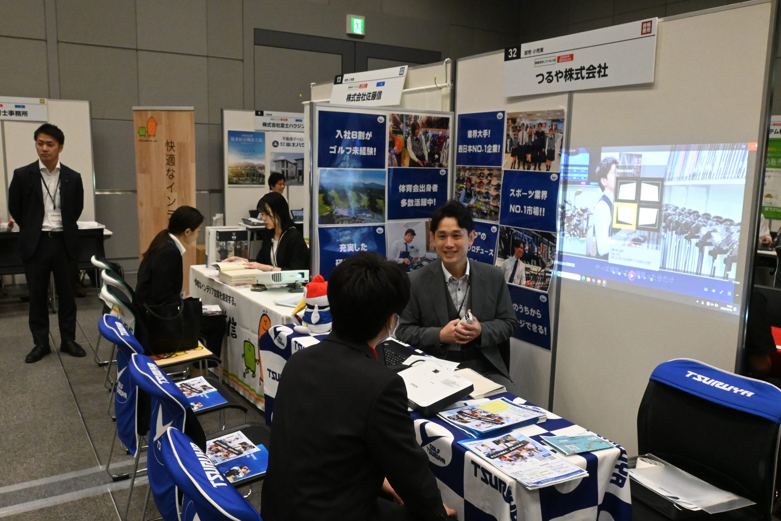 企業ブースで求職者（右手前）に自社のアピールをする社員（右奥、10月13日、ハービスホール）